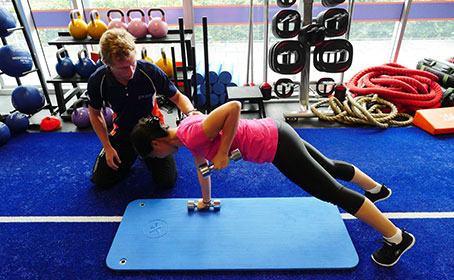 woman in the gym with her coach have a workout session